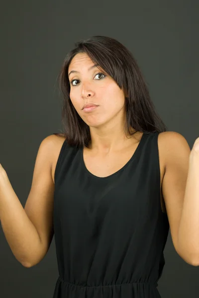 Confused young  woman shrugging with arms outstretched — Stock Photo, Image