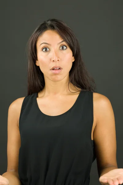 Shocked young  woman shrugging with arms outstretched — Stock Photo, Image