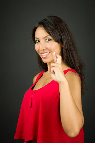 Giovane donna mostrando le dita incrociate e sorridente — Foto Stock