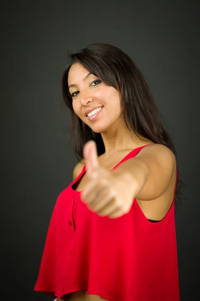 Selbstbewusste junge Frau zeigt Daumen hoch und lächelt — Stockfoto