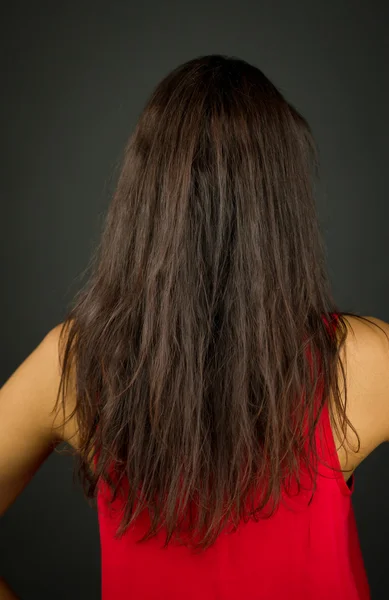 Visão traseira de uma jovem mostrando seu cabelo comprido — Fotografia de Stock