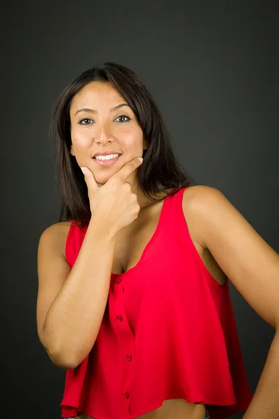 Portrait of a young woman smiling with her hand on chin — Stock Photo, Image