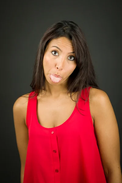 Portrait of a young woman sticking out her tongue — Stock Photo, Image