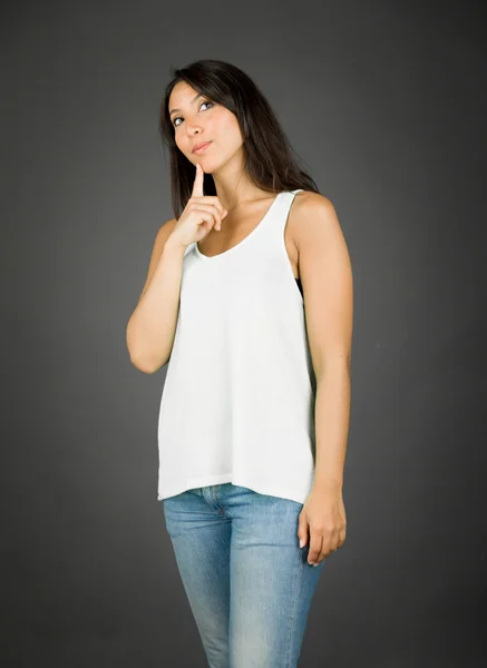 Young woman looking up with her finger on chin — Stock Photo, Image