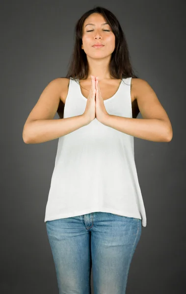 Junge Frau steht in Gebetsposition und meditiert — Stockfoto