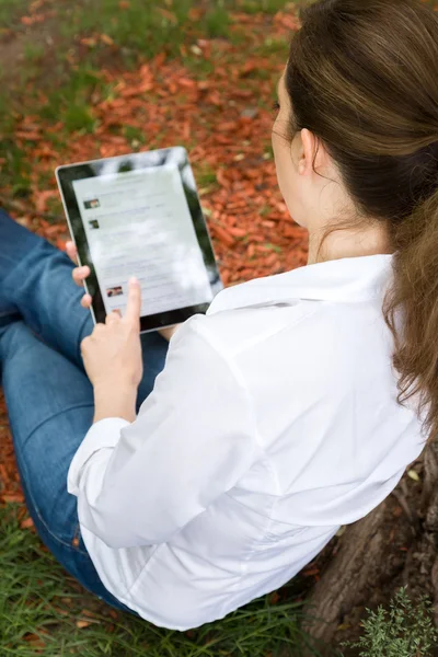 Vrouw in park met digitale tablet — Stockfoto