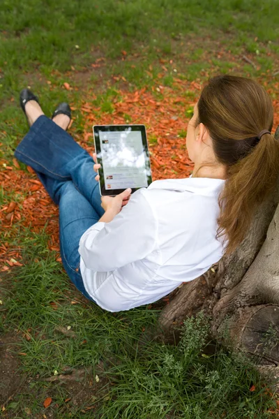 Vrouw in park met digitale tablet — Stockfoto