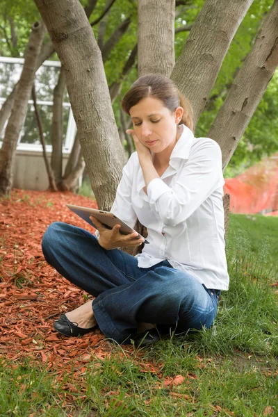 Vrouw in park met digitale tablet — Stockfoto