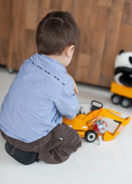 Küçük bir çocuk evde oyuncakla oynamak arka görünüm