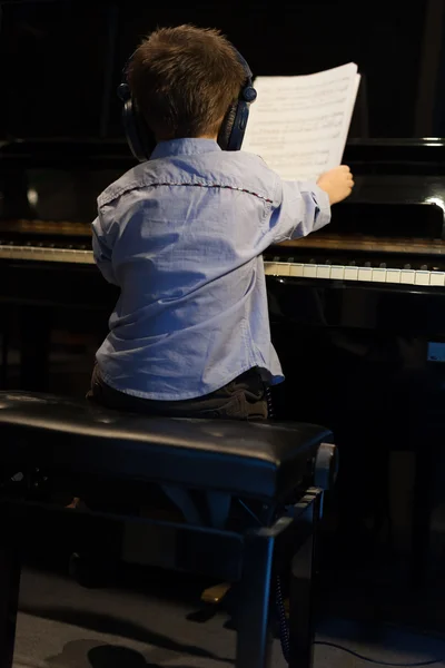 Achteraanzicht van een kleine jongen leren piano — Stockfoto