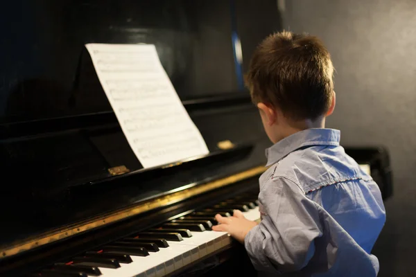 Профіль маленького хлопчика, який вивчає фортепіано — стокове фото