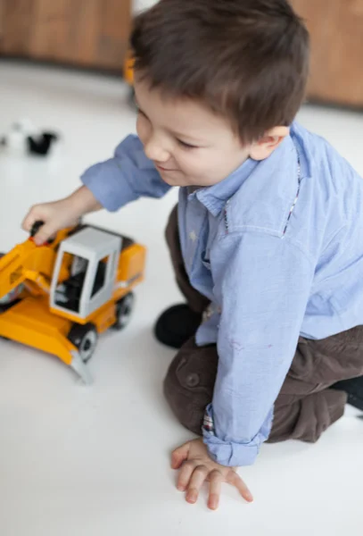 Roztomilý malý chlapec hraje s jeřábem hračku doma — Stock fotografie