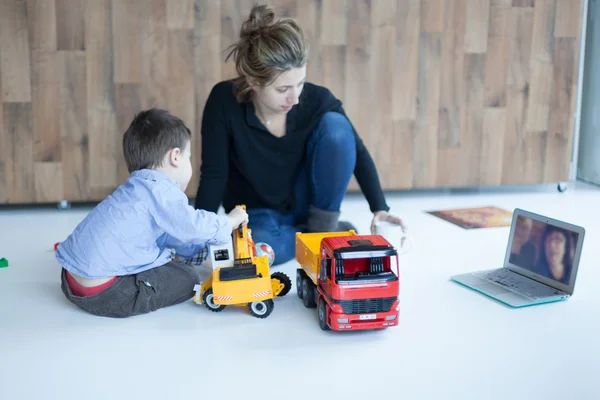 Garçon jouant des jouets avec sa mère vidéo appelant ses parents — Photo