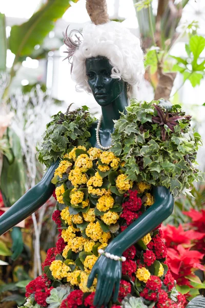 Statue wearing clothes made of colorful Christmas flowers displayed at Allan Gardens, Toronto, Ontario, Canada — Stock Photo, Image