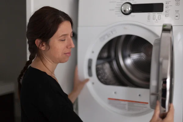 Bir çamaşır makinesi kullanan orta yetişkin kadın profili Telifsiz Stok Imajlar
