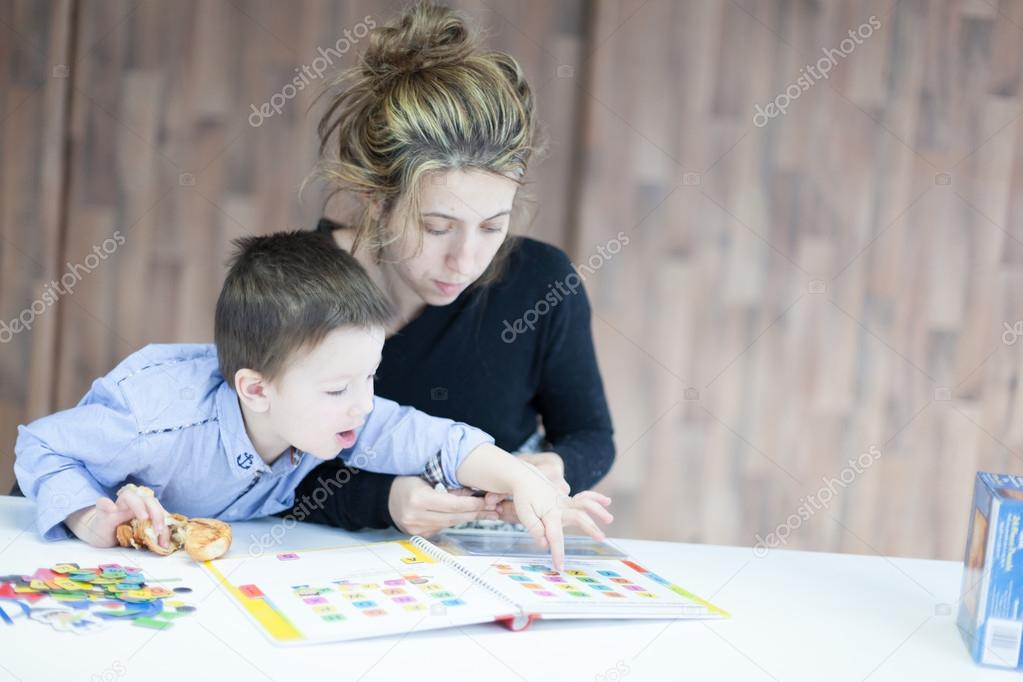 Little boy playing puzzles with his mother