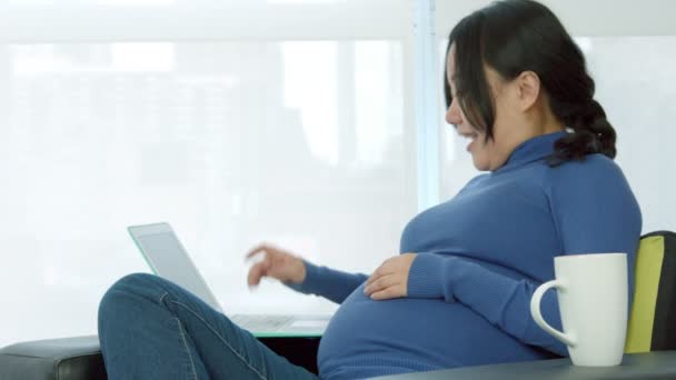 Mulher grávida sentada em um sofá — Vídeo de Stock