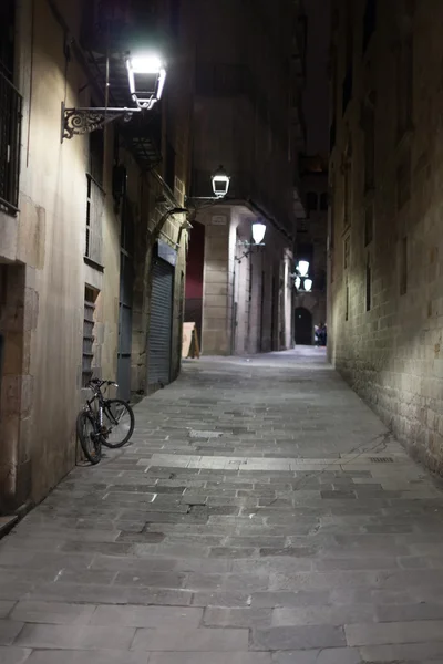 Prázdné úzké uličky pouliční lampy v noci osvětlené, Barcelona, Španělsko — Stock fotografie