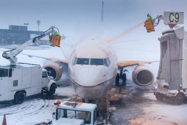 Airport attendant washing airplane in winter weather at an airport — Stock Photo, Image