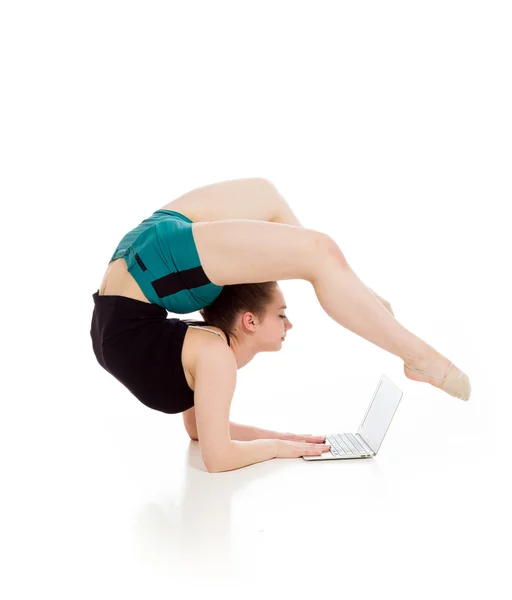 Gymnastikmodell Stretching mit Laptop — Stockfoto