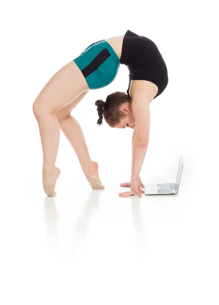 Gymnastikmodell Stretching mit Laptop — Stockfoto