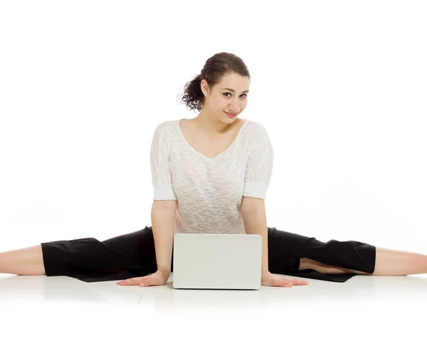 Gymnastiska modellen stretching med laptop — Stockfoto