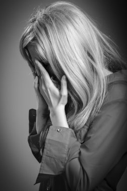 Mutsuz kadın elleriyle yüzünü kaplayan