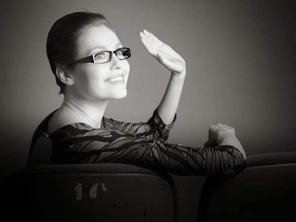 Mulher acenando a mão no cinema — Fotografia de Stock