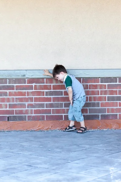 Niño apoyado contra una pared —  Fotos de Stock