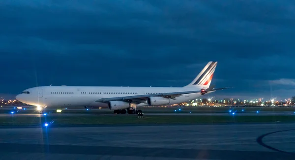 Flygplan som står på banan vid flygplatsen i natt — Stockfoto