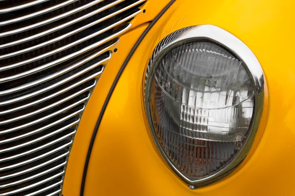 Right headlight of a yellow vintage car — Stock Photo, Image