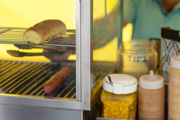 Dodavatel, příprava hotdog v kabince trhu — Stock fotografie