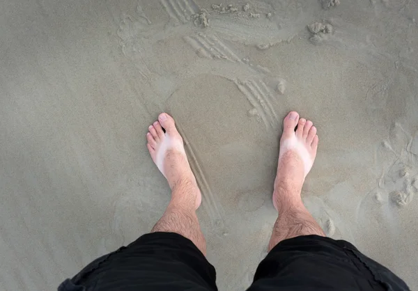 Πόδια που στέκεται πάνω σε μια αμμώδη παραλία — Φωτογραφία Αρχείου