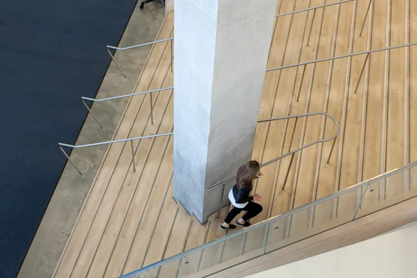 Жінка ходить по сходах в офісному будинку — стокове фото