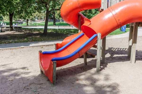 Diapositiva roja en un patio de recreo —  Fotos de Stock