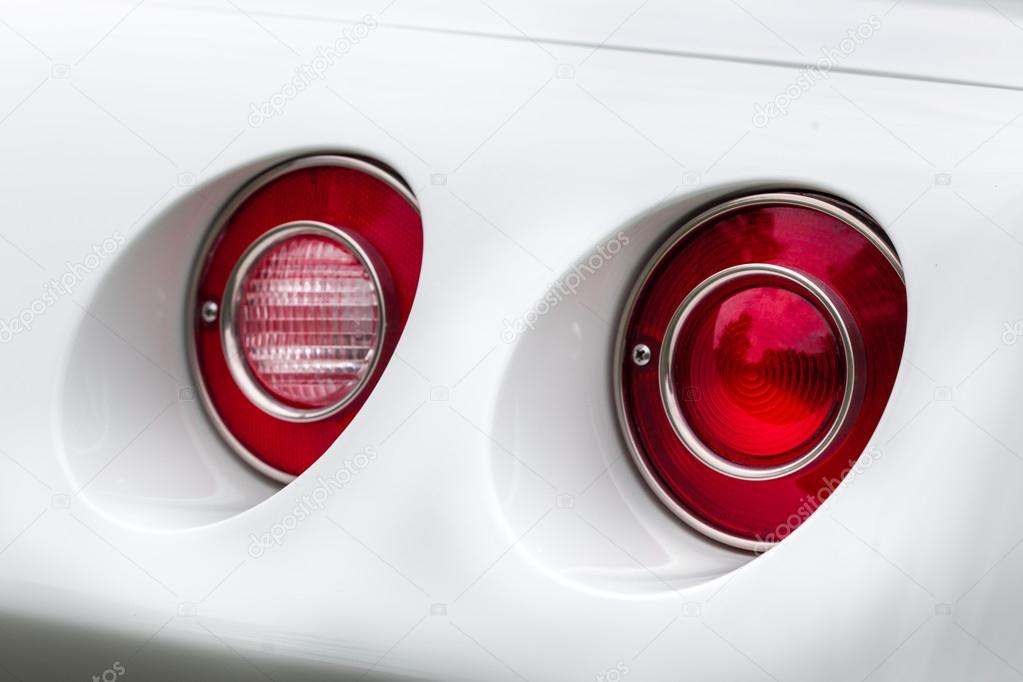 Red tail lights of a white vintage car