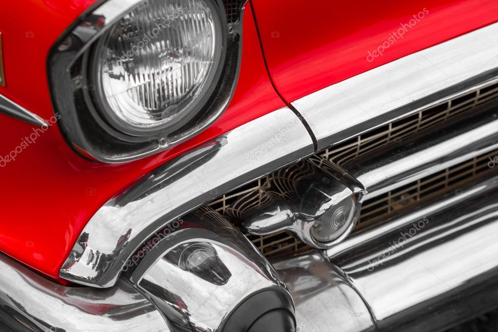 Left headlight of a red vintage car 