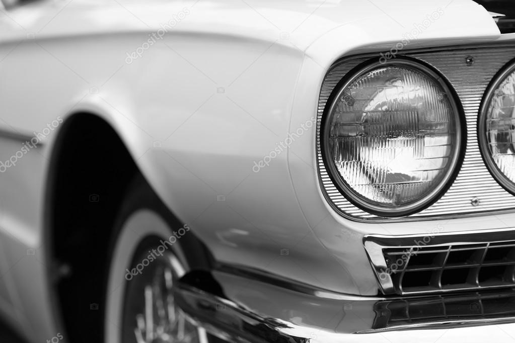 Left headlights of a white vintage car 