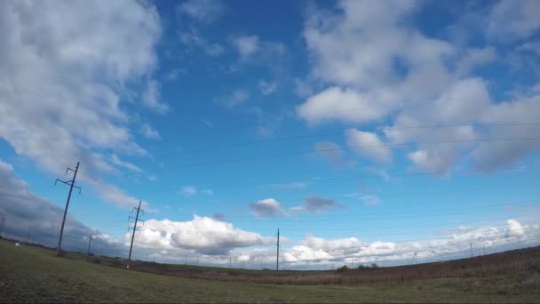 Nuages de Timelapse sur le champ vert et le marais avec ligne électrique aérienne — Video