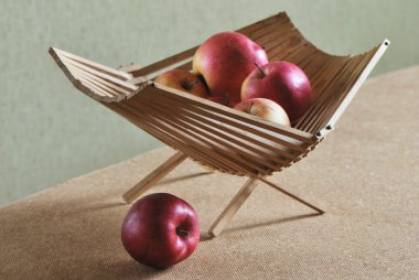 yeşil zemin üzerine ahşap sepet içinde kırmızı elmalar