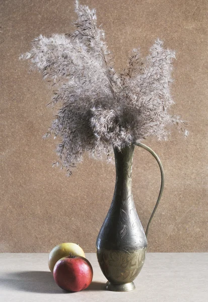 Foto de jarra de cobre y dos manzanas sobre fondo de madera — Foto de Stock