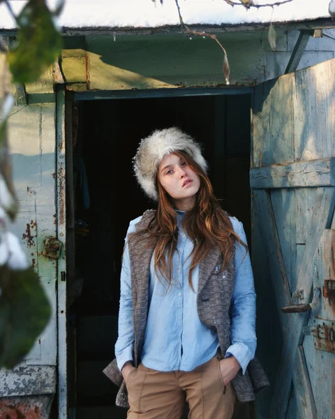 Autunno ritratto foto di bella ragazza fredda con cappello di pelliccia e cappotto di pelle in piedi sulla porta — Foto Stock