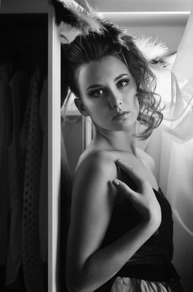Foto de retrato de una hermosa chica mirando a la cámara con vestido en el fondo de la cortina. foto en blanco y negro — Foto de Stock