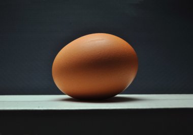 Gri studio arka plan üzerinde beyaz yüzey üzerinde yumurta