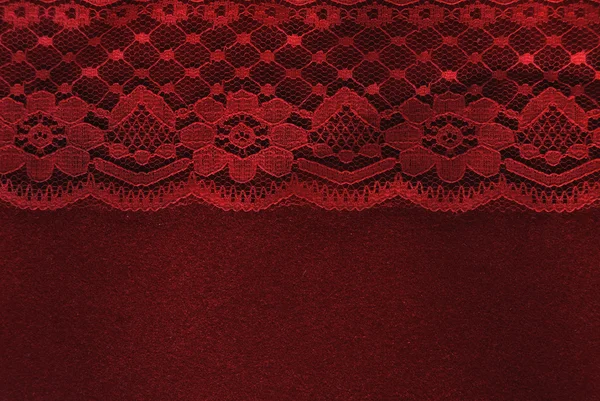 Encaje rojo sobre fondo de papel de terciopelo rojo — Foto de Stock
