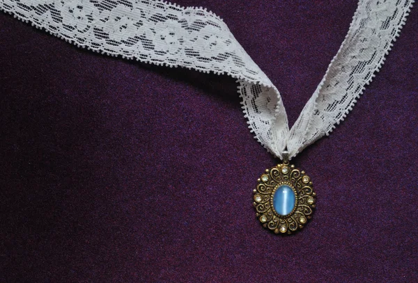 Foto della collana di pietra di luna con pizzo bianco su sfondo di velluto viola — Foto Stock