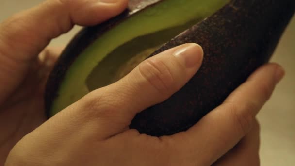 Öppnande av halverad avokado med händer — Stockvideo
