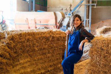 Genç kadın ahırda çalışıyor.