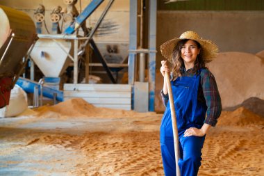 Çiftlikte şapkası olan gülümseyen bir kadın.