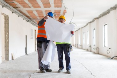 Bina planlarına bakan iş arkadaşları